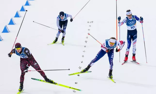 Julian Schmid, of Germany, from left, Ryota Yamamoto, of Japan, Niklas Malacinski, of the United States, and Marco Heinis, of France, approach the finish line in the nordic combined individual Gundersen large hill/10km at the 2026 Winter Olympics, in Tesero, Italy, Tuesday, Feb. 17, 2026. (AP Photo/Kirsty Wigglesworth)