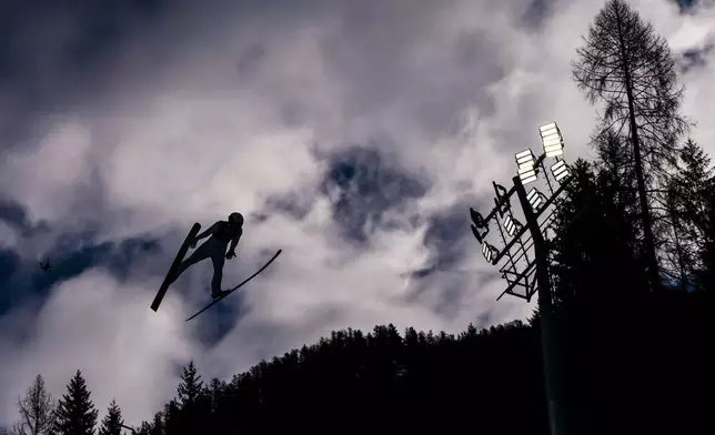Ryota Yamamoto, of Japan, soars through the air during his competition round jump of the nordic combined individual Gundersen large hill/10km at the 2026 Winter Olympics, in Predazzo, Italy, Tuesday, Feb. 17, 2026. (AP Photo/Kirsty Wigglesworth)