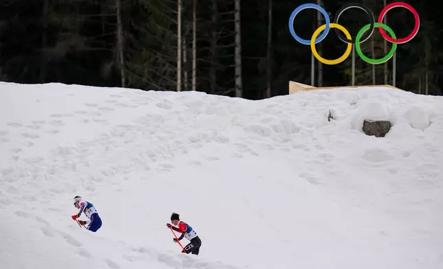 Benjamin Loomis, of the United States, left, and Jiri Konvalinka, of Czechia, compete in the nordic combined individual Gundersen large hill/10km at the 2026 Winter Olympics, in Tesero, Italy, Tuesday, Feb. 17, 2026. (AP Photo/Evgeniy Maloletka)