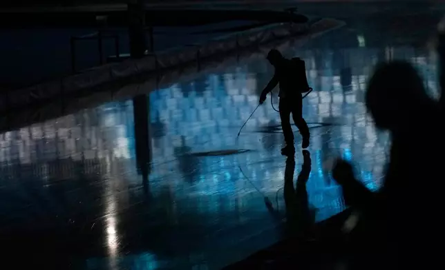 Cracks in the ice are being repaired ahead of team pursuit speedskating races at the 2026 Winter Olympics, in Milan, Italy, Tuesday, Feb. 17, 2026. (AP Photo/Luca Bruno)