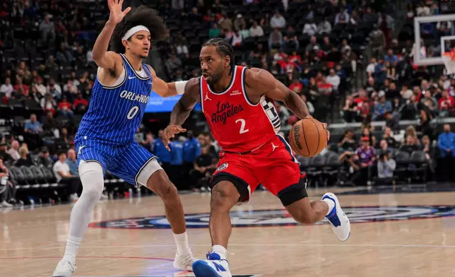 Los Angeles Clippers forward Kawhi Leonard, right, dribbles past Orlando Magic guard Anthony Black during the second half of a NBA basketball game, Sunday, Feb. 22, 2026, in Inglewood, Calif. (AP Photo/Etienne Laurent)