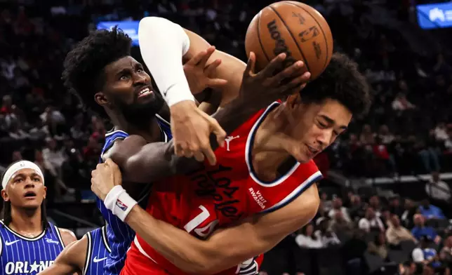 Orlando Magic forward Jonathan Isaac, left, and Los Angeles Clippers center Yanic Konan Niederhauser fight for a rebound during the second half of a NBA basketball game, Sunday, Feb. 22, 2026, in Inglewood, Calif. (AP Photo/Etienne Laurent)