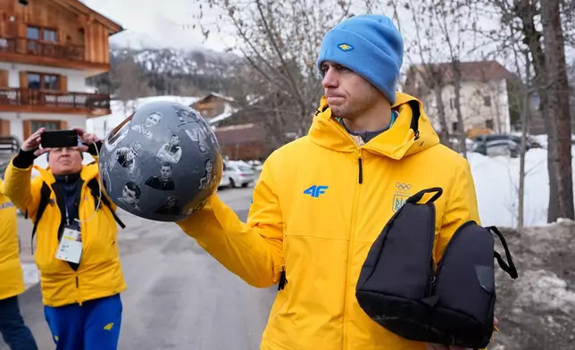Ukrainian skeleton athlete Vladyslav Heraskevych holds his crash helmet as he stands outside the sliding center at the 2026 Winter Olympics, in Cortina d'Ampezzo, Italy, Thursday, Feb. 12, 2026. (AP Photo/Alessandra Tarantino)