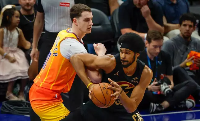 Cleveland Cavaliers center Jarrett Allen, right, drives against Charlotte Hornets center Ryan Kalkbrenner, left, during the first half of an NBA basketball game in Charlotte, N.C., Friday, Feb. 20, 2026. (AP Photo/Nell Redmond)