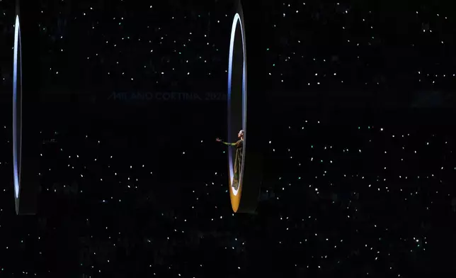 An artist performs as the Olympic rings come together during the Olympic opening ceremony at the 2026 Winter Olympics, in Milan, Italy, Friday, Feb. 6, 2026. (AP Photo/Francisco Seco)