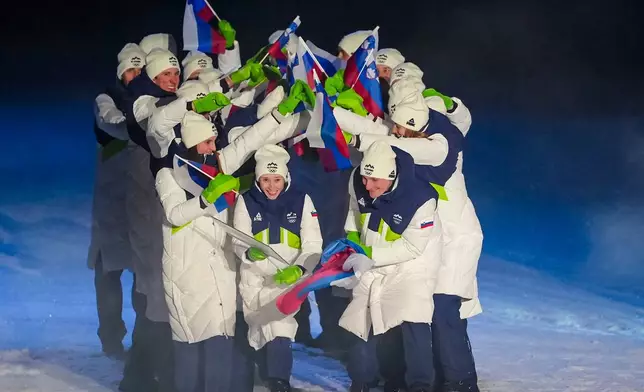 Nika Prevc and Domen Prevc, the flag bearers of Slovenia, take part in the athletes parade during the Olympic opening ceremony at the 2026 Winter Olympics, in Predazzo, Italy, Friday, Feb. 6, 2026. (AP Photo/Kirsty Wigglesworth)