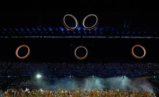The Olympic rings begin to form during a performance at the Olympic opening ceremony at the 2026 Winter Olympics, in Milan, Italy, Friday, Feb. 6, 2026. (AP Photo/Natacha Pisarenko)