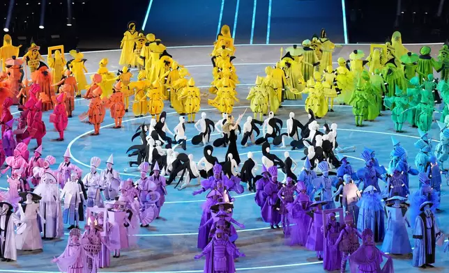 Volunteers perform during the opening ceremony at the Milan Cortina Winter Olympics, in Milan, Friday, Feb. 6, 2026. (Nathan Denette /The Canadian Press via AP)