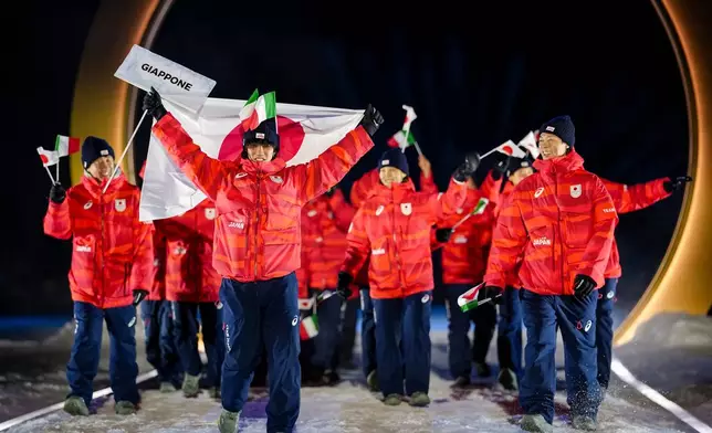 Japan athletes take part in the athletes parade during the Olympic opening ceremony at the 2026 Winter Olympics, in Predazzo, Italy, Friday, Feb. 6, 2026. (AP Photo/Matthias Schrader)