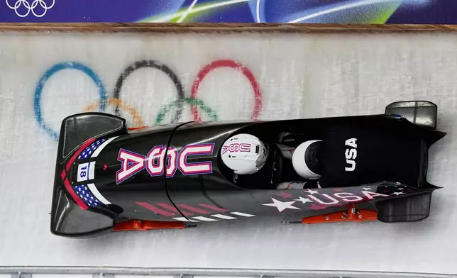 United States' Frankie del Duca, left, slides down the track during a two man bobsled training session at the 2026 Winter Olympics, in Cortina d'Ampezzo, Italy, Saturday, Feb. 14, 2026. (AP Photo/Aijaz Rahi)