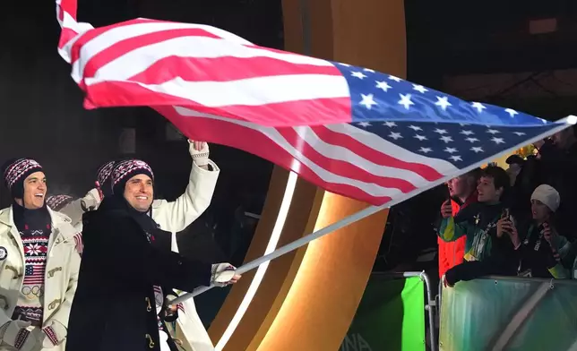 Frankie del Duca, flag bearer of United States, leads his team in during the Olympic opening ceremony at the 2026 Winter Olympics, in Cortina d'Ampezzo, Italy, Friday, Feb. 6, 2026. (AP Photo/Misper Apawu)
