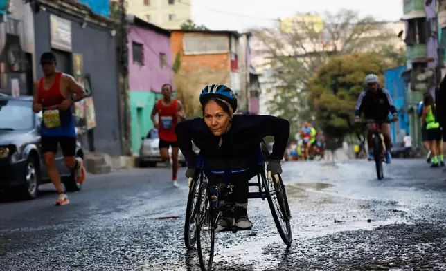A competitor pushes her wheelchair during the CAF Marathon in Caracas, Venezuela, Sunday, Feb. 8, 2026. (AP Photo/Cristian Hernandez)
