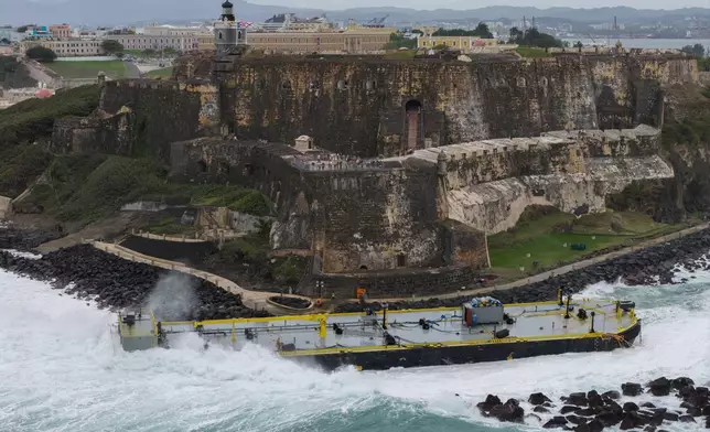 A fuel barge sits grounded near the Castillo San Felipe del Morro by San Juan Bay in San Juan, Puerto Rico, Tuesday, Feb. 10, 2026. (AP Photo/Alejandro Granadillo)