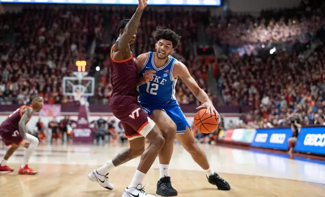 Duke forward Cameron Boozer (12) is stoppped by Virginia Tech forward Tobi Lawal (1) during the first half of an NCAA college basketball game, Saturday, Jan. 31, 2026, in Blacksburg, Va. (AP Photo/Robert Simmons)
