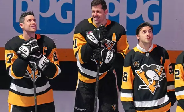 Members of the 2016 Stanley Cup Champion Pittsburgh Penguins, Sidney Crosby, left, Evgeni Malkin, center, and Kris Letang take part in a celebration of the 10th anniversary before an NHL hockey game against the New York Rangers in Pittsburgh, Saturday, Jan. 31, 2026. (AP Photo/Gene J. Puskar)