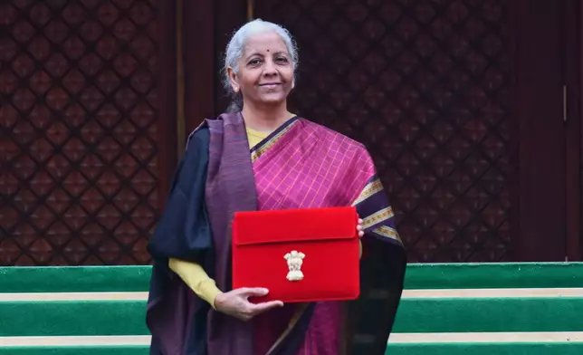 Indian Finance Minister Nirmala Sitharaman displays a red folder containing the Union Budget 2026-27 at the steps of the parliament house before tabling it, in New Delhi, India, Sunday, Feb. 1, 2026. (AP Photo)