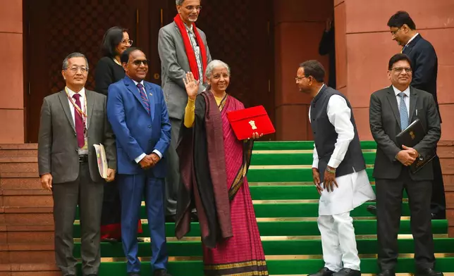 Indian Finance Minister Nirmala Sitharaman, center, displays a red folder containing the Union Budget 2026-27 at the steps of the parliament house before tabling it, in New Delhi, India, Sunday, Feb. 1, 2026. (AP Photo)