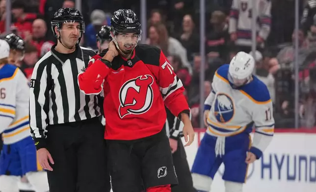 New Jersey Devils' Jack Hughes (86) drives past Buffalo Sabres' Jack Quinn (22)during the second period of an NHL hockey game Wednesday, Feb. 25, 2026, in Newark, N.J. (AP Photo/Frank Franklin II)