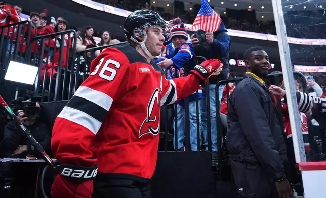New Jersey Devils' Jack Hughes (86) greets fans as he walks toward the ice before an NHL hockey game against the Buffalo Sabres Wednesday, Feb. 25, 2026, in Newark, N.J. (AP Photo/Frank Franklin II)