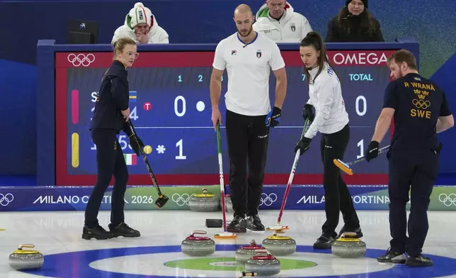 Italy's Amos Mosaner and Stefania Constantini and Sweden's Isabella Wranaa and Rasmus Wranaa compete during the mixed doubles round robin phase of the curling competition, at the 2026 Winter Olympics, in Cortina d'Ampezzo, Italy, Saturday, Feb. 7, 2026. (AP Photo/Misper Apawu)