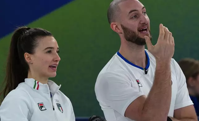 Italy's Amos Mosaner and Stefania Constantini strategize during the mixed doubles round robin phase of the curling competition against Sweden, at the 2026 Winter Olympics, in Cortina d'Ampezzo, Italy, Saturday, Feb. 7, 2026. (AP Photo/Misper Apawu)