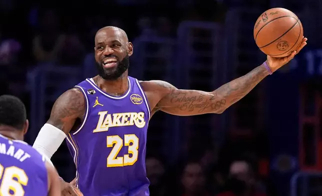 Los Angeles Lakers forward LeBron James smiles as he tries to pass during the first half of an NBA basketball game against the Dallas Mavericks, Thursday, Feb. 12, 2026, in Los Angeles. (AP Photo/Mark J. Terrill)