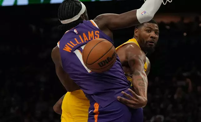 Los Angeles Lakers guard Marcus Smart makes the pass around Phoenix Suns center Mark Williams (15) during the first half of an NBA basketball game, Thursday, Feb. 26, 2026, in Phoenix. (AP Photo/Rick Scuteri)