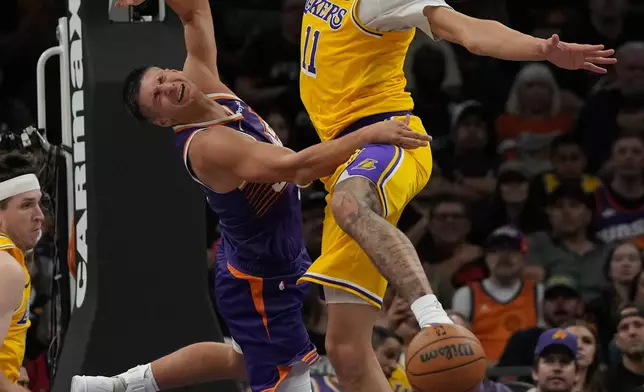 Los Angeles Lakers center Jaxson Hayes (11) fouls Phoenix Suns guard Grayson Allen during the first half of an NBA basketball game, Thursday, Feb. 26, 2026, in Phoenix. (AP Photo/Rick Scuteri)