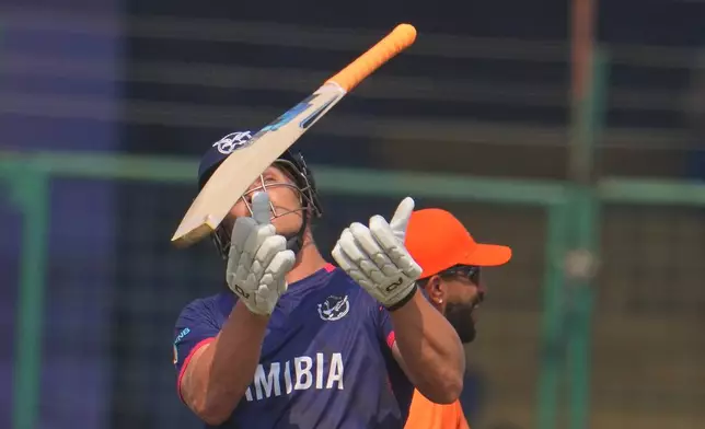 Namibia's Ruben Trumpelmann throws his bat up in the air after losing his wicket during the T20 World Cup cricket match between Namibia and Netherlands in New Delhi, India, Tuesday, Oct. 10, 2026.(AP Photo/Manish Swarup)