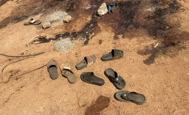 Flip flop shoes and blood stains cover the street days after an attack in the village of Woro, Nigeria, Thursday, Feb. 5, 2026. (AP Photo/Musa Salim)