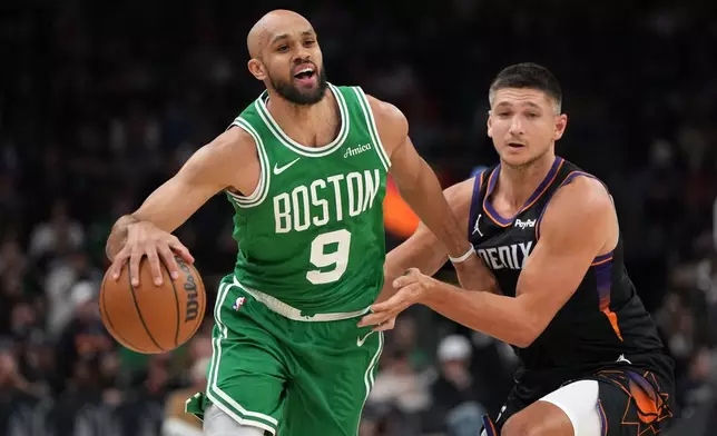 Boston Celtics guard Derrick White (9) drives past Phoenix Suns guard Grayson Allen during the first half of an NBA basketball game, Tuesday, Feb. 24, 2026, in Phoenix. (AP Photo/Rick Scuteri)