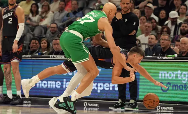 Boston Celtics guard Jordan Walsh (27) fouls Phoenix Suns guard Grayson Allen during the first half of an NBA basketball game, Tuesday, Feb. 24, 2026, in Phoenix. (AP Photo/Rick Scuteri)