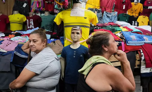Vendors wait for customers at a market that primarily sells clothing imported from China in Asuncion, Paraguay, Saturday, Jan. 31, 2026. (AP Photo/Jorge Saenz)