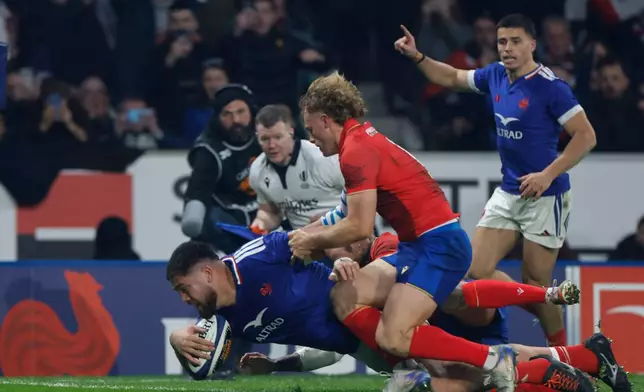 France's Emmanuel Meafou, left, scores a try as Italy's Louis Lynagh tries to defend during the Six Nations rugby union match between France and Italy in Lille, France, Sunday, Feb. 22, 2026. (AP Photo/Jean-Francois Badias)