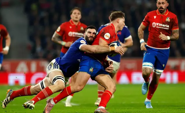Italy's Leonardo Marin, center, is tackled by France's Charles Ollivon during the Six Nations rugby union match between France and Italy in Lille, France, Sunday, Feb. 22, 2026. (AP Photo/Jean-Francois Badias)