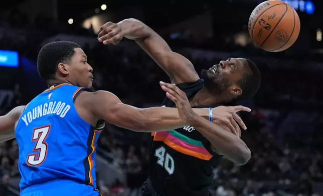 San Antonio Spurs forward Harrison Barnes (40) is fouled by Oklahoma City Thunder guard Chris Youngblood (3) as he drives to the basket during the second half of an NBA basketball game in San Antonio, Wednesday, February. 4, 2026. (AP Photo/Eric Gay)
