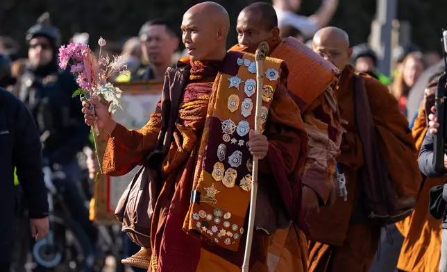 Monk Bhikkhu Pannakara walks along with Buddhist monks who are participating in a Walk For Peace walk through a the streets of Washington, Tuesday, Feb. 10, 2026, (AP Photo/Jose Luis Magana)