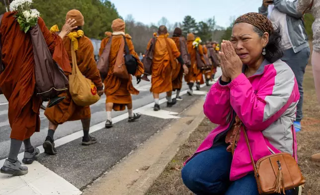 FILE - A woman reacts as Buddhist monks on a "Walk for Peace" walk past on Veterans Parkway in Fayetteville, Ga., Dec. 29, 2025. (Arvin Temkar/Atlanta Journal-Constitution via AP File)