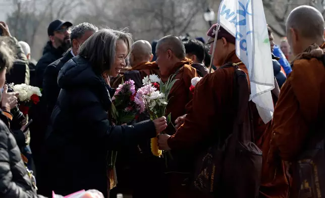 Sen. Lisa Blunt Rochester, D-DE., left, greeting Buddhist monks as they walk near the Peace Monument on Capitol Hill, during the Walk For Peace, Wednesday, Feb. 11, 2026, in Washington. (AP Photo/Rahmat Gul)
