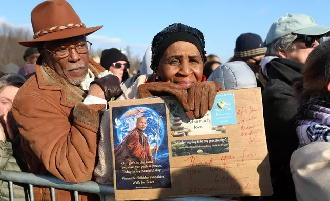 People watch at the Lincoln Memorial during the Buddhist monks walk For Peace, Wednesday, Feb. 11, 2026, in Washington. (AP Photo/Rahmat Gul)