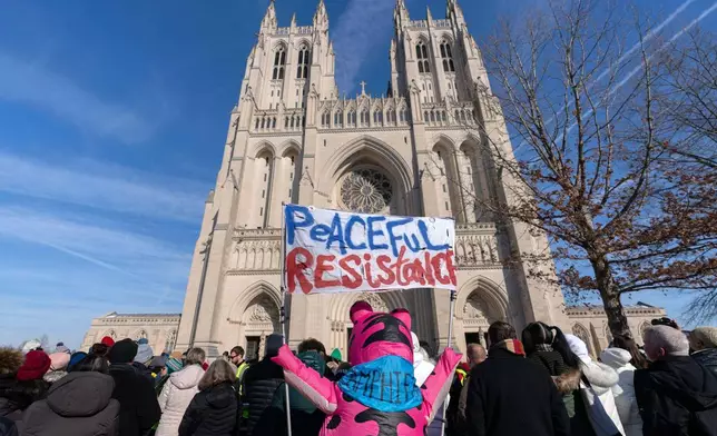 People gather to watch the Buddhist monks as they walk outside of the Washington National Cathedral after an event during the Walk For Peace, Tuesday, Feb. 10, 2026, in Washington. (AP Photo/Jose Luis Magana)