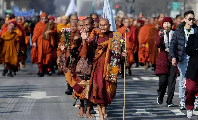 Buddhist monks walk near the Peace Monument on Capitol Hill, during the Walk For Peace, Wednesday, Feb. 11, 2026, in Washington. (AP Photo/Rahmat Gul)