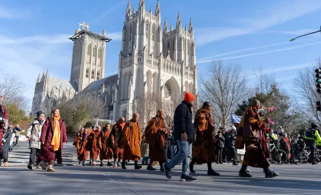 Buddhist monks walk outside of the Washington National Cathedral after and event they participated during the Walk For Peace, Tuesday, Feb. 10, 2026, in Washington. (AP Photo/Jose Luis Magana)