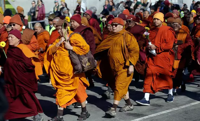Buddhist monks walk on the National Mall during the Walk For Peace, Wednesday, Feb. 11, 2026, in Washington. (AP Photo/Rahmat Gul)