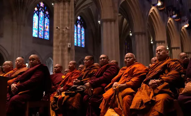Buddhist monks sit in Washington National Cathedral during an event with monks who are participating in a Walk For Peace, Tuesday, Feb. 10, 2026, in Washington. (AP Photo/Mark Schiefelbein)
