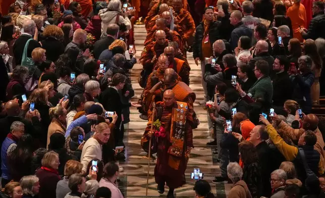 Monk Bhikkhu Pannakara, front, and his fellow Buddhist monks leave after an event at Washington National Cathedral to mark their Walk For Peace, Tuesday, Feb. 10, 2026, in Washington. (AP Photo/Mark Schiefelbein)