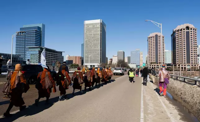 Venerable Buddhist monks cross the 9th Street bridge during a walk for peace into downtown Richmond, Va., Monday, Feb. 2, 2026. (Mike Kropf/Richmond Times-Dispatch via AP)