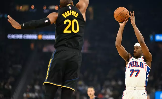 Philadelphia 76ers guard VJ Edgecombe (77) attempts a 3-point basket against Golden State Warriors center Al Horford (20) during the first half of an NBA basketball game, Tuesday, Feb. 3, 2026, in San Francisco. (AP Photo/Eakin Howard)