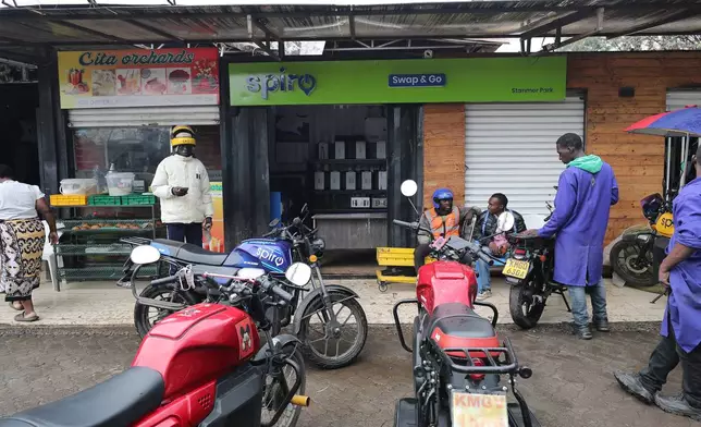 Riders swap batteries at an electric Spiro motorcycle charging station in Nairobi, Kenya, Tuesday, Feb. 24, 2026. (AP Photo/Henry Naminde)