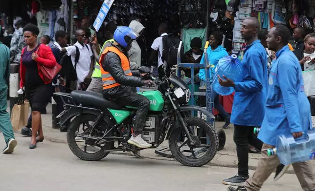 A man rides an electric Spiro motorcycle in Nairobi, Kenya, Tuesday, Feb. 24, 2026. (AP Photo/Henry Naminde)